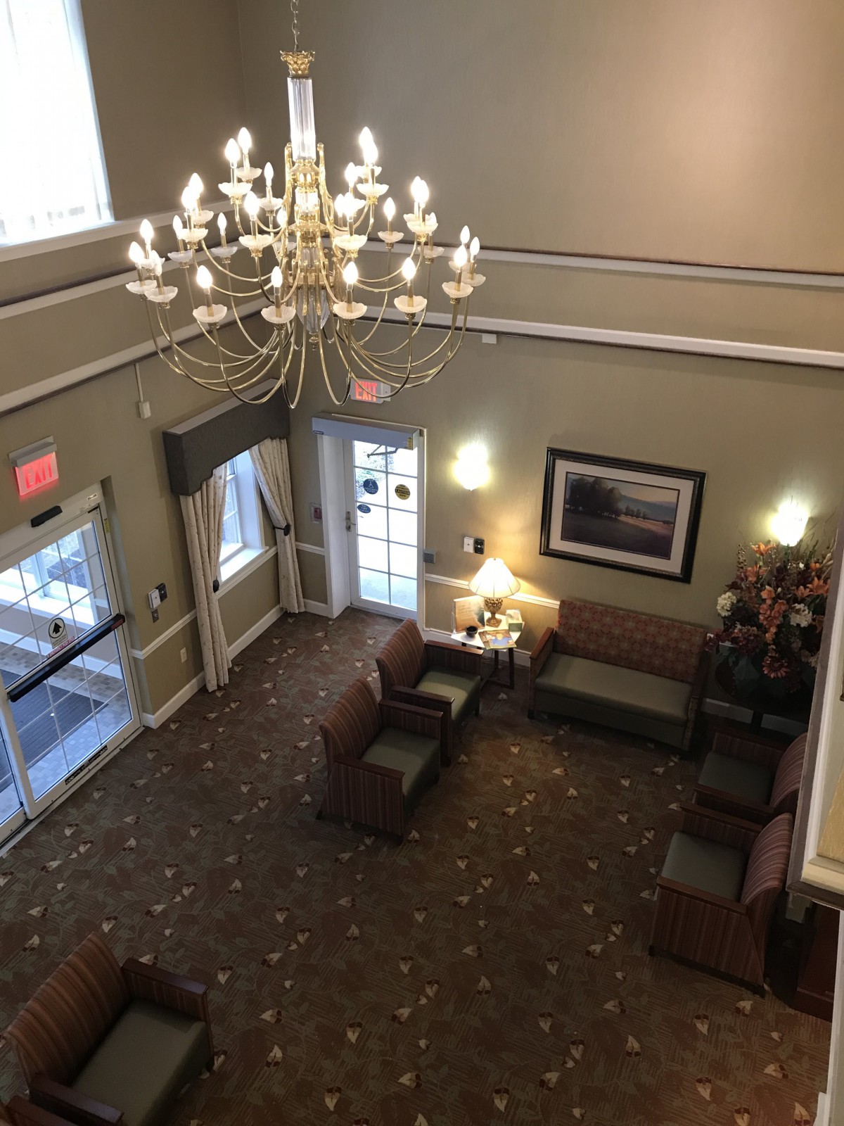 A spacious hotel lobby with elegant chandeliers and comfortable seating.