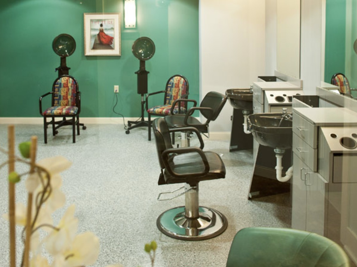 An empty hair salon with styling chairs and equipment.
