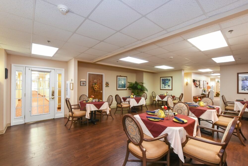 A cozy dining room with elegantly set tables and chairs, featuring a warm interior decor.