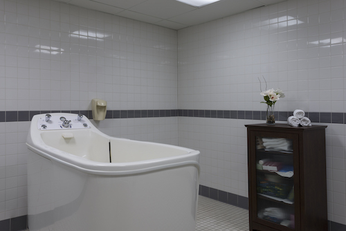 A modern bathroom featuring a bathtub, elegant tiles, and a touch of decoration.