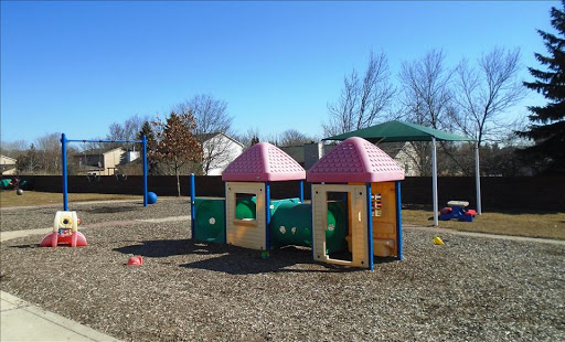 A vibrant playground featuring colorful playhouses and a tunnel, perfect for children's outdoor activities.