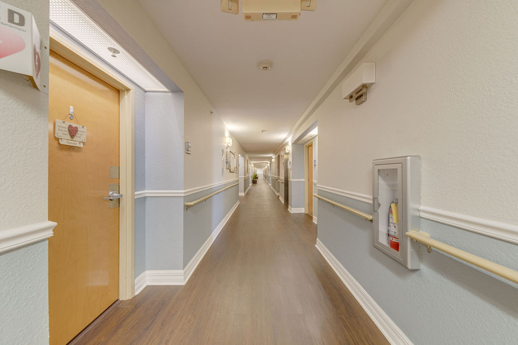 A brightly lit corridor with multiple doors and wall-mounted fixtures.
