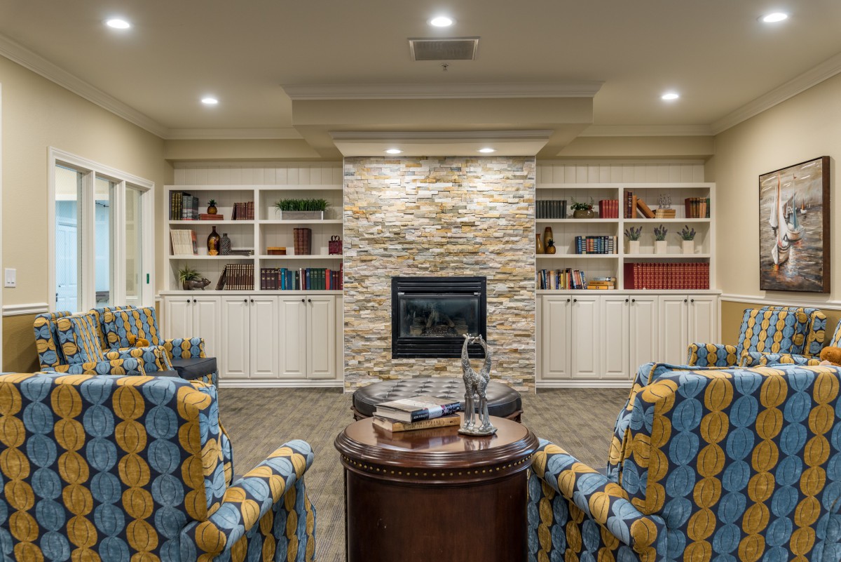 A cozy living room featuring a central fireplace and built-in bookshelves with comfortable seating.