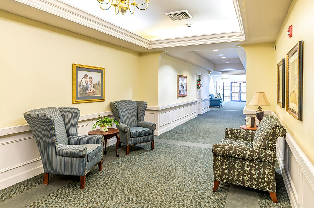 A cozy and well-decorated interior lobby with chairs, a sofa, and artwork on the walls.