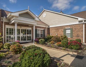 A charming residential building with a landscaped entrance and brick exterior.