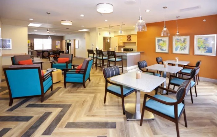 A modern and cozy lounge area with various seating arrangements and a warm color palette.