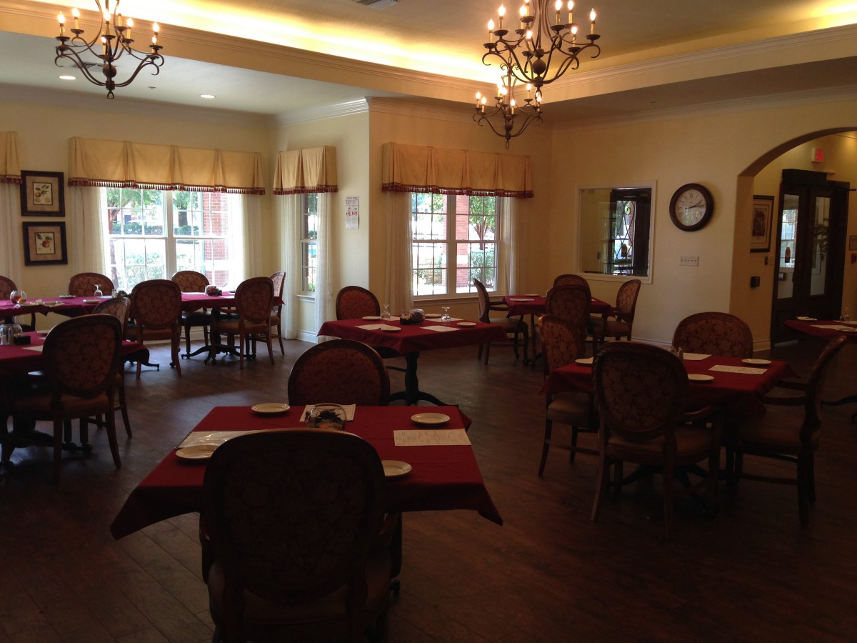 A cozy restaurant dining area with elegantly arranged tables and chandeliers.
