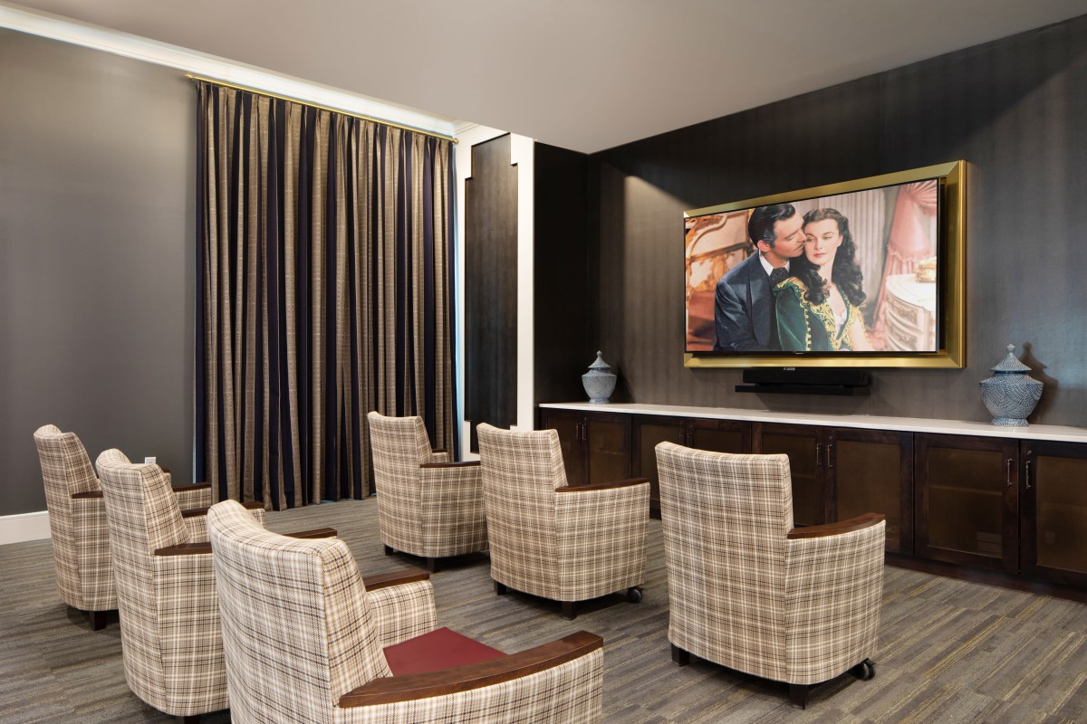 A cozy home theater setup with comfortable seating and a large TV screen.