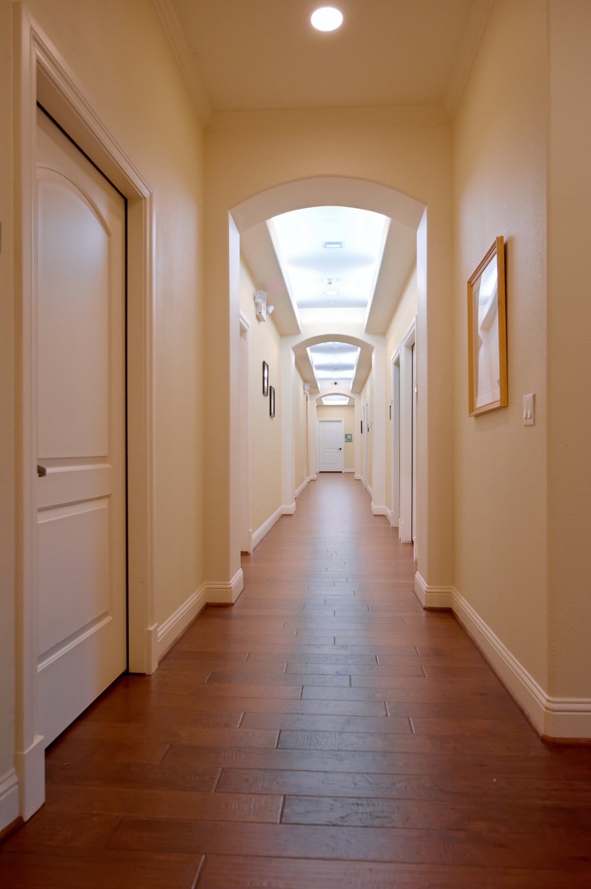 A well-lit hallway with several doors on each side.