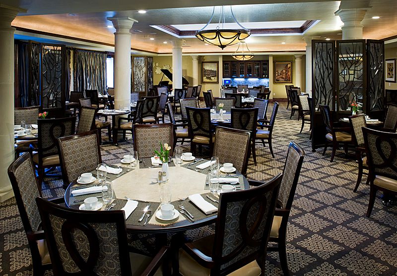 An elegant dining room with neatly arranged tables and chairs, ready for guests.