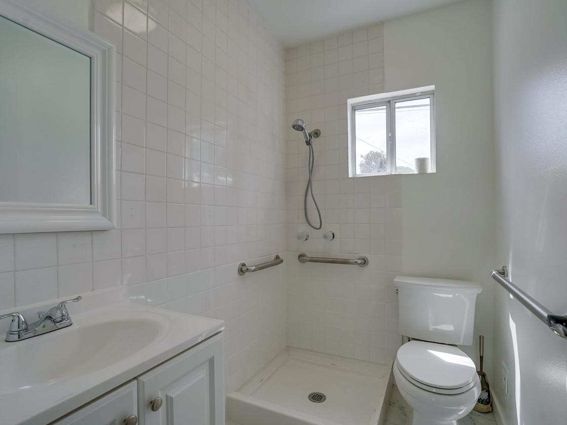 A modern bathroom with a shower, toilet, and sink.