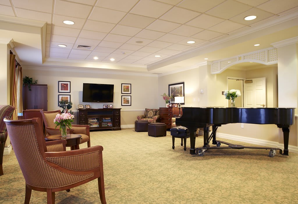 A spacious and elegant living room with a grand piano and comfortable seating.