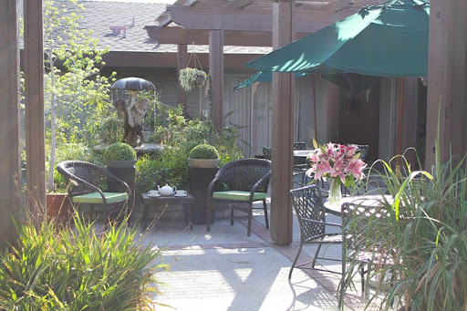 A serene outdoor patio adorned with comfortable seating and vibrant flowers, perfect for relaxation.
