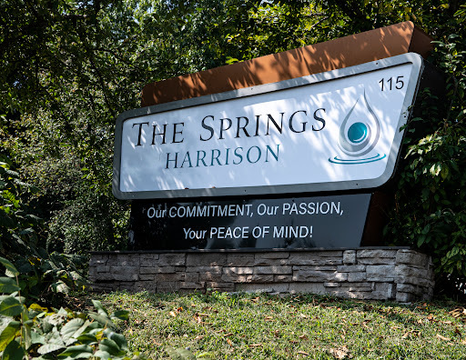 Signage for 'The Springs Harrison', emphasizing commitment and peace of mind.