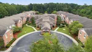 Aerial view of a residential building complex surrounded by lush greenery.