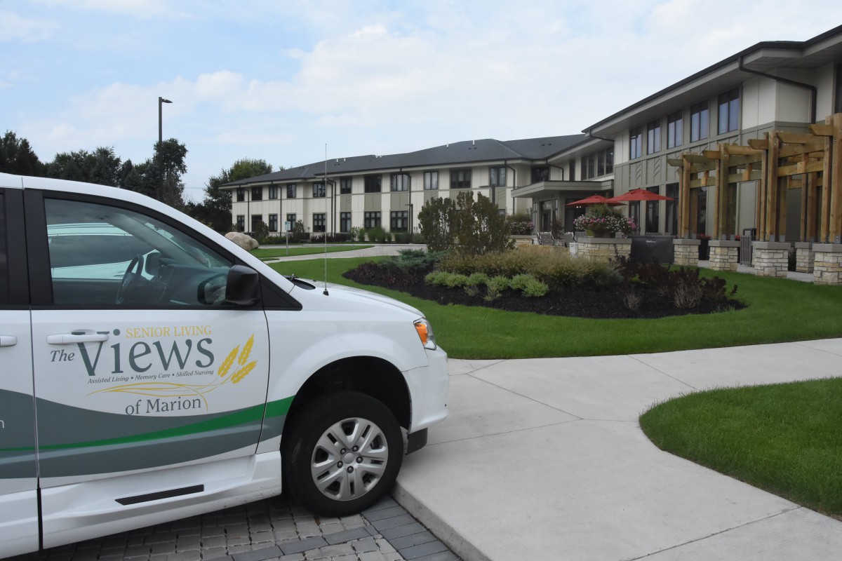 A van parked in front of a modern building with landscaped greenery.