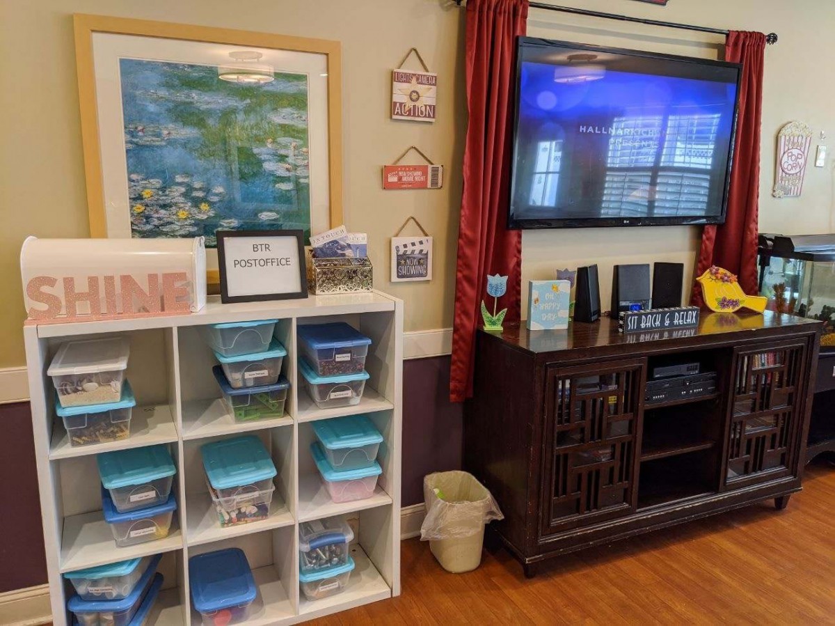 A well-organized classroom corner with storage bins and a television for educational purposes.