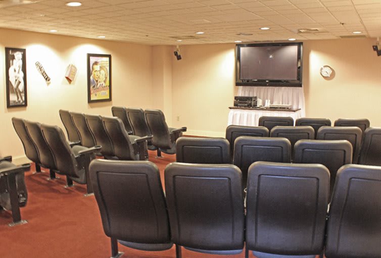 A small conference room with rows of seats facing a television.