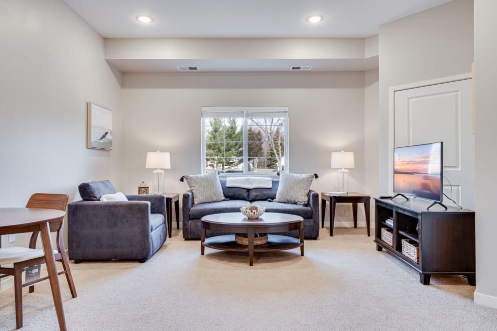 A cozy and well-lit living room featuring comfortable seating, a central coffee table, and stylish decor.