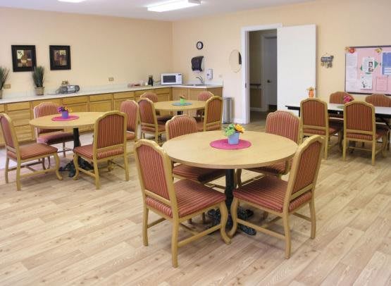 An empty dining room with several tables and chairs arranged neatly.