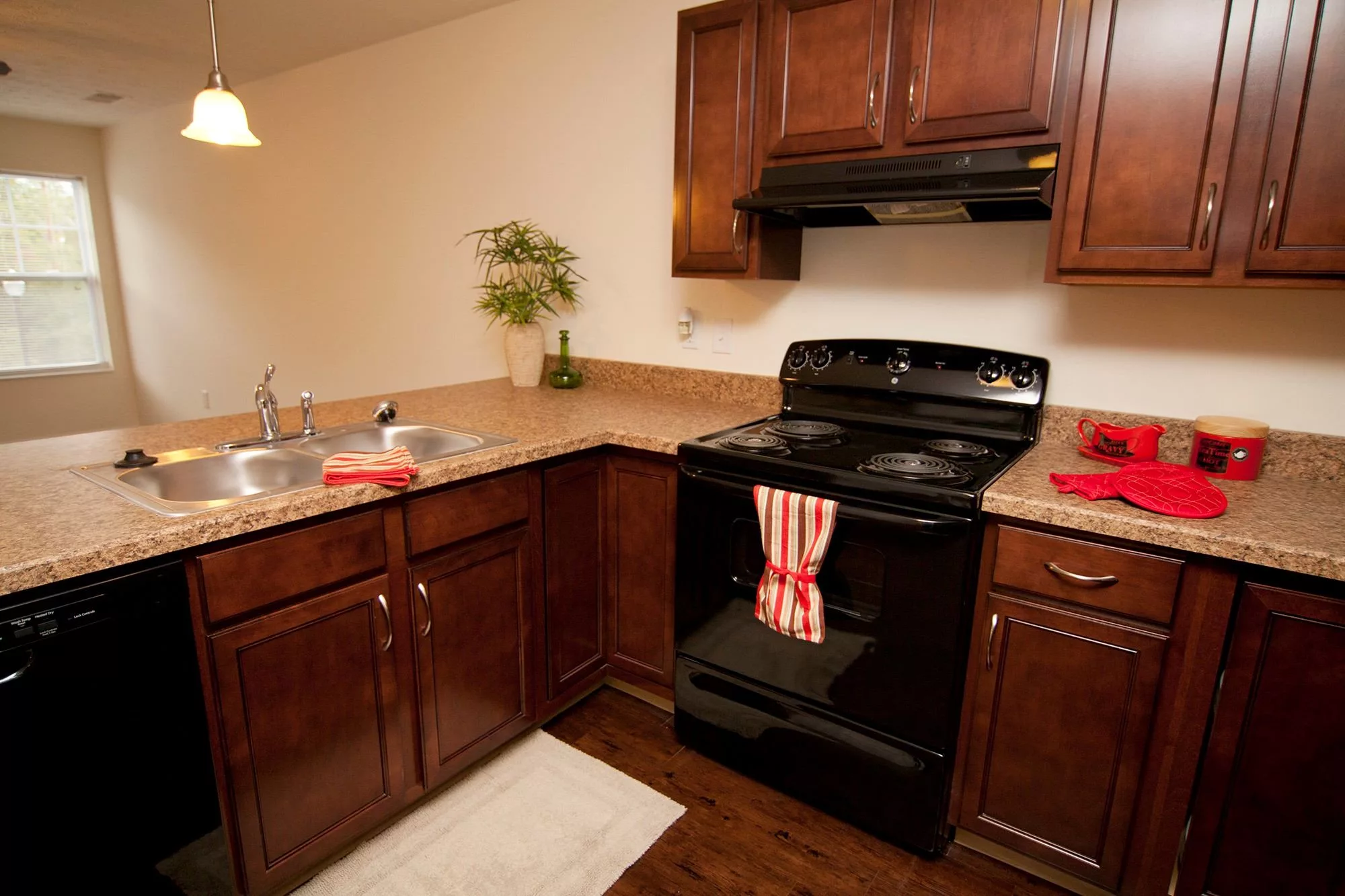 A cozy kitchen with wooden cabinets and a black stove.
