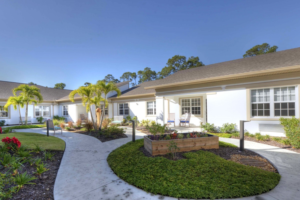 A scenic view of a modern residential building with a landscaped garden and pathway.