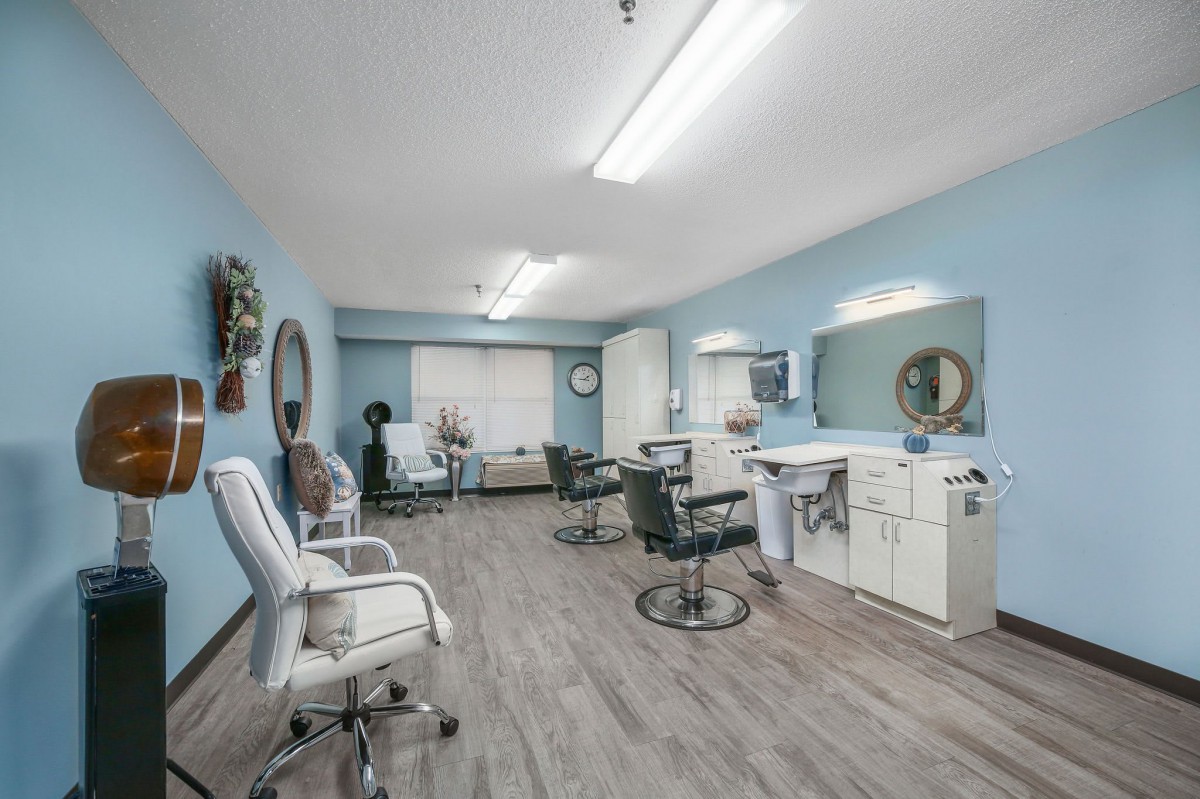 A spacious and well-lit hair salon with multiple styling stations and mirrors.