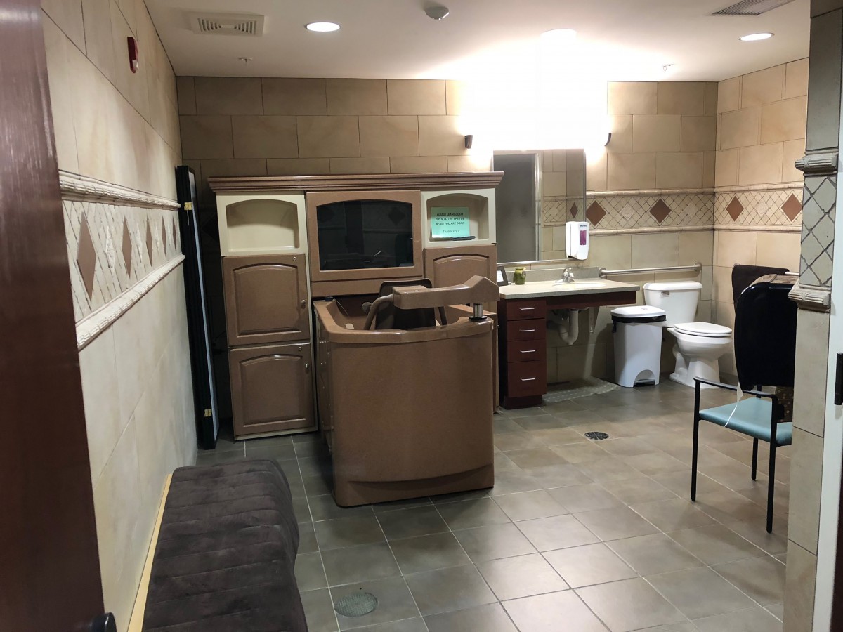 A spacious bathroom with a spa chair and modern amenities.