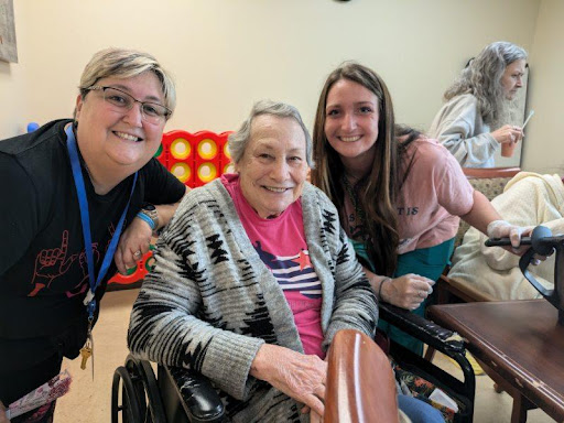 A joyful moment shared among caregivers and an elderly resident.