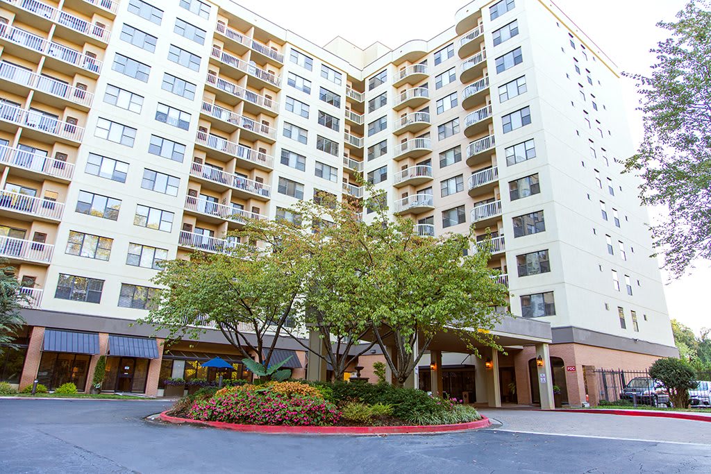 A high-rise residential building with landscaped surroundings.