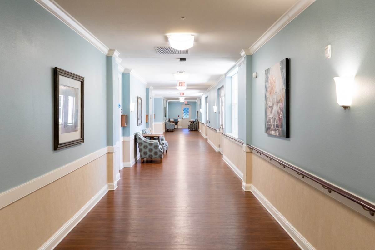 A well-lit hallway with art on the walls and comfortable seating areas.