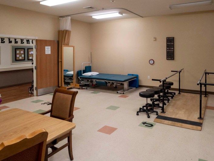 A physical rehabilitation room with exercise equipment and therapy beds.