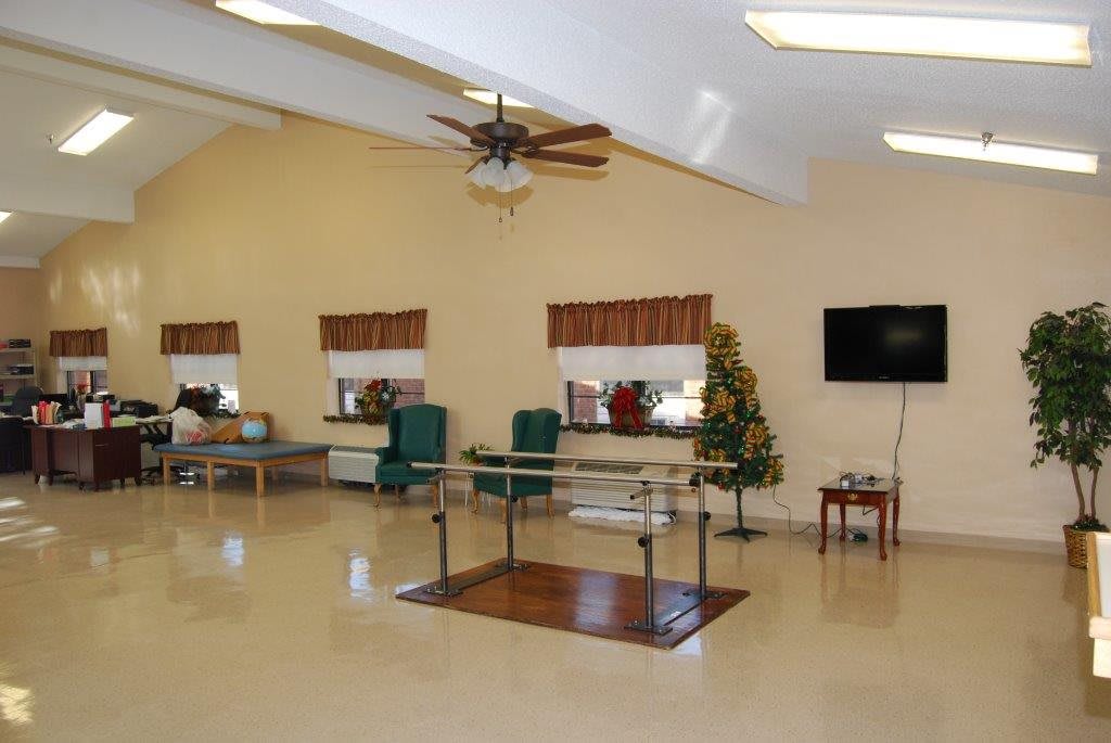 A therapy room equipped with exercise equipment in a healthcare facility.