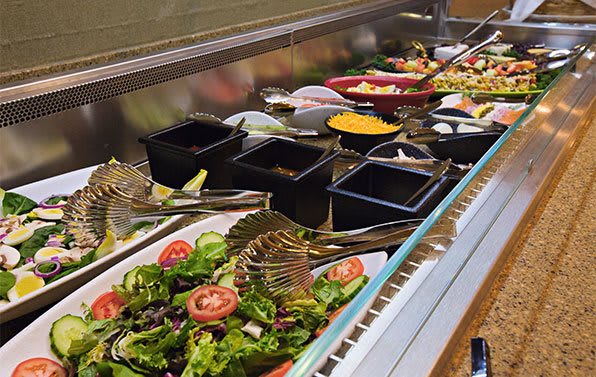 A vibrant salad bar with a variety of fresh vegetables and toppings.