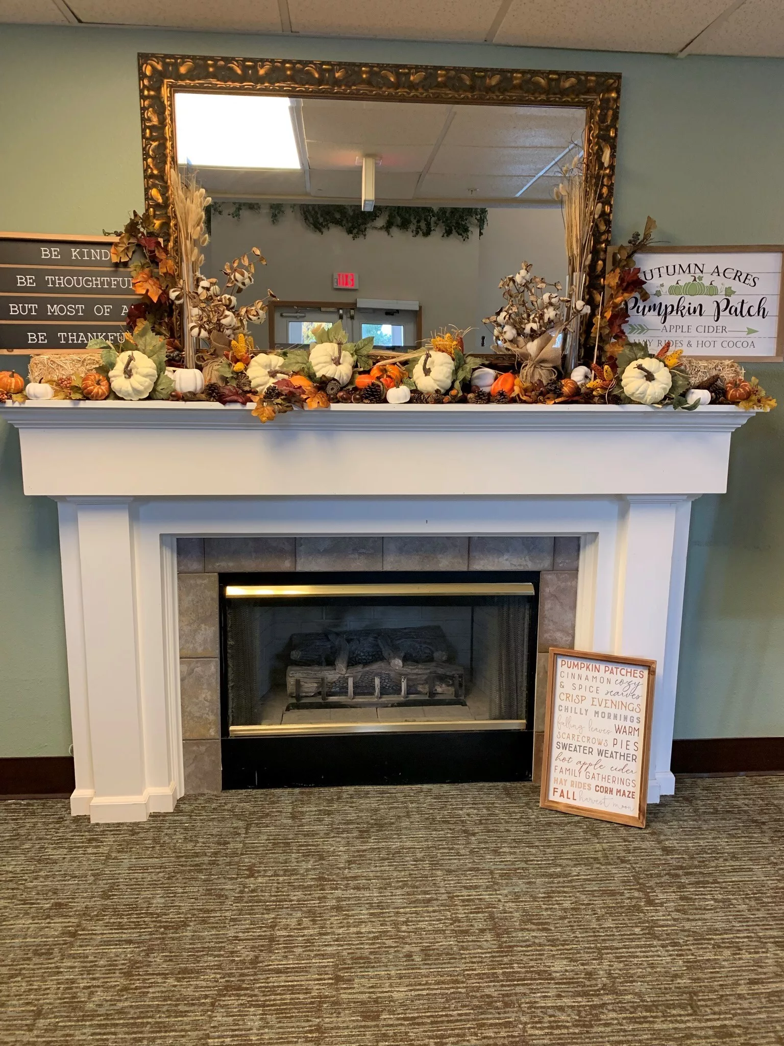 A cozy fireplace adorned with autumn-themed decorations and pumpkins on the mantel.