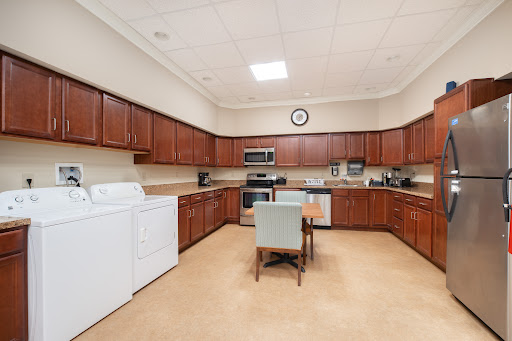 A spacious kitchen featuring wooden cabinets, modern appliances, and a cozy dining area.