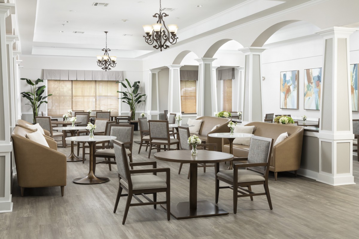A spacious and elegantly designed dining area with modern furniture and bright lighting.