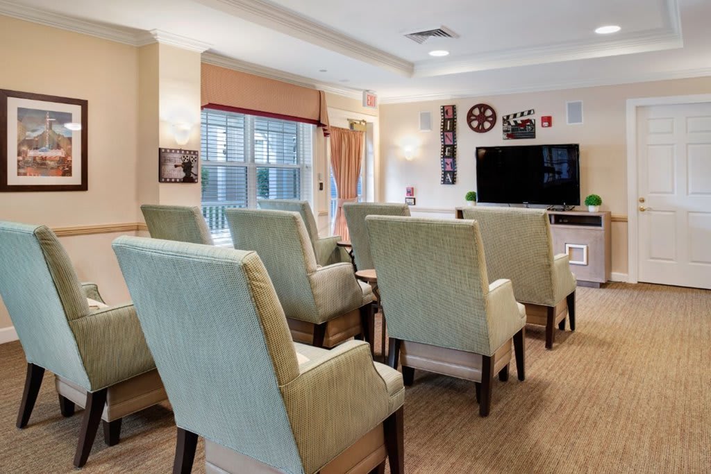 A cozy home theater room with comfortable seating and a large TV.
