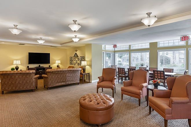 A spacious and well-lit living room with comfortable seating and a TV.