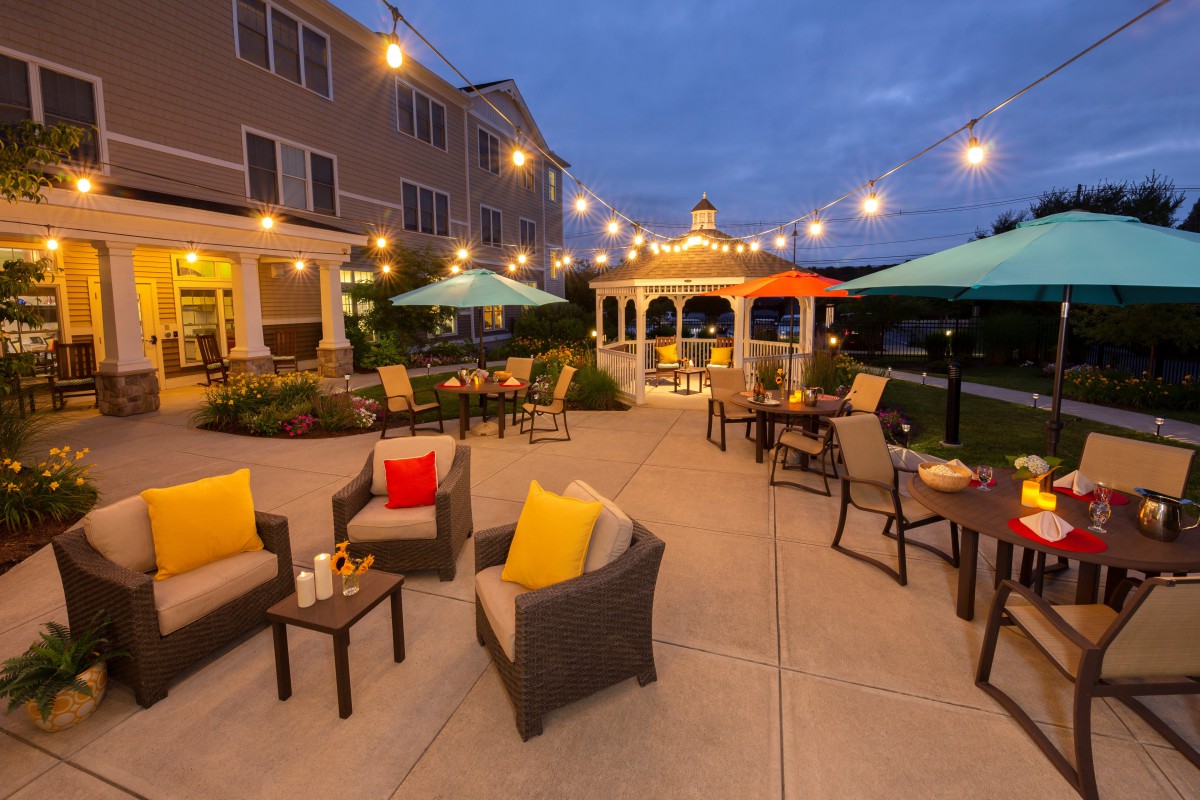A cozy outdoor patio with string lights and comfortable seating.
