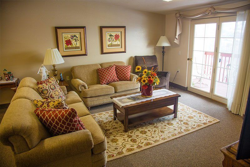 A cozy living room featuring a sofa, coffee table, and decorative elements such as artwork and lamps.