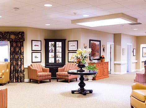 A spacious lobby with comfortable seating, artwork, and floral decorations.