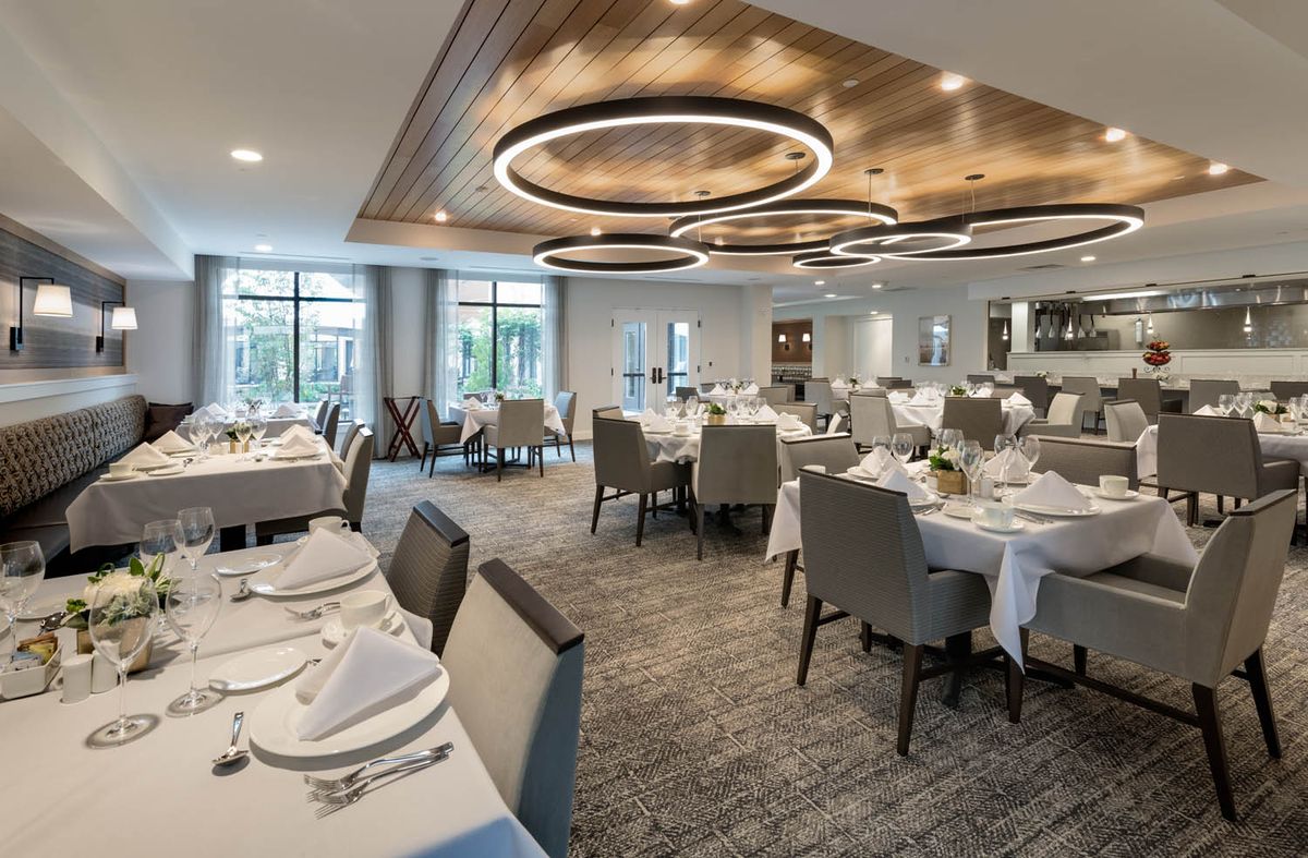 A modern restaurant interior with elegantly set tables and stylish lighting.