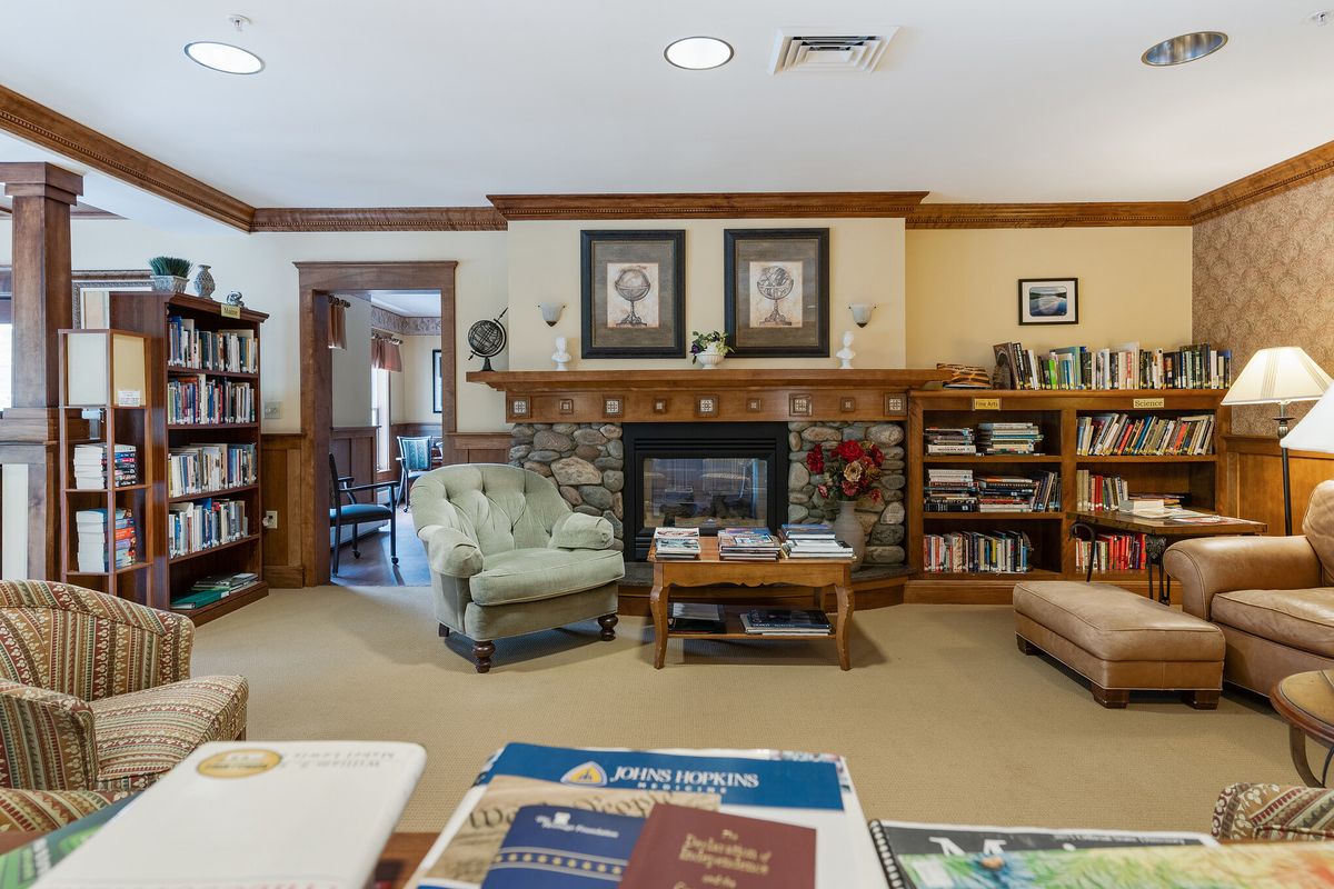A cozy living room with bookshelves, a fireplace, and comfortable seating.