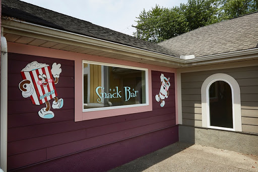 A colorful exterior of a snack bar featuring playful cartoon character murals.
