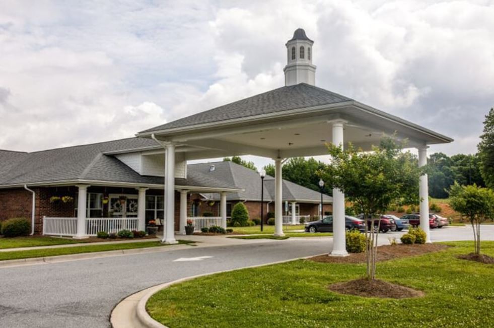 A building with a covered entrance and landscaped surroundings.