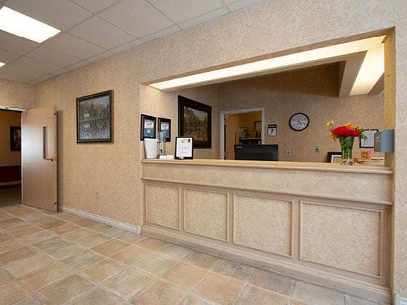 A neat and organized reception desk with a flower arrangement in an office setting.