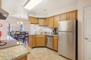 A modern kitchen with wood cabinets and stainless steel appliances.