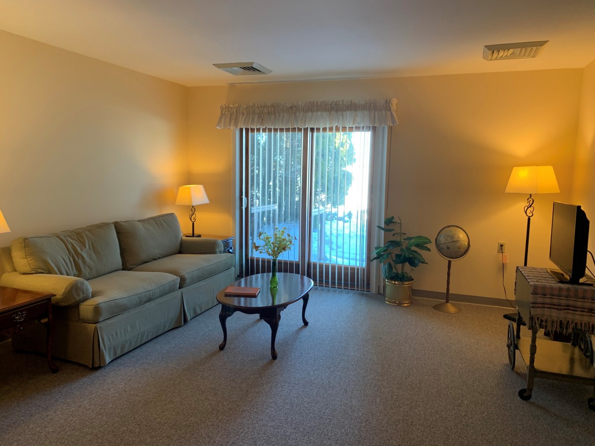 A cozy living room with a sofa, coffee table, and warm lighting.
