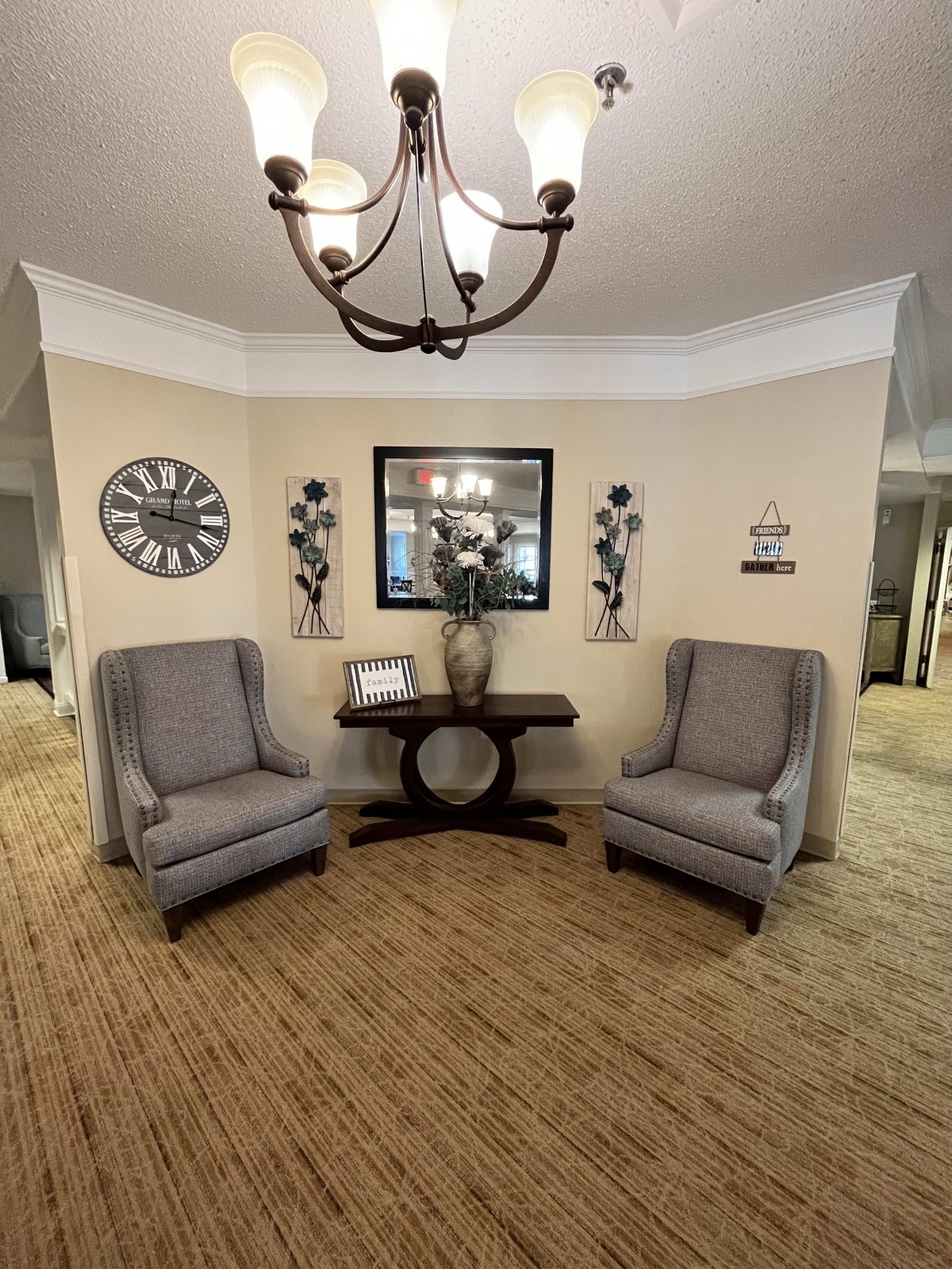 A cozy seating area with two armchairs, a table, and decorative elements.